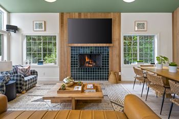 A living room with a fireplace and a flat screen TV. at Lakemont Orchard Apartments, Washington